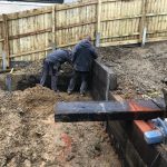 AMONGST THE MUDDY CHAOS, DION'S WALLS EMERGE WITH STEEL I-BEAMS AND TROPICAL HARDWOOD RAILWAY SLEEPERS