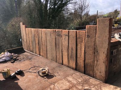 DION'S ENTRANCE WALL WITH VERTICALLY PLACED TROPICAL HARDWOOD RAILWAY SLEEPERS 