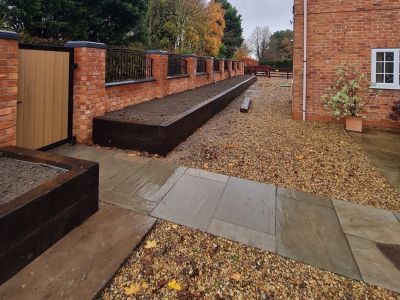 AN EYE-CATCHING BOUNDARY OF RAISED BEDS FROM RECLAIMED AZOBE RAILWAY SLEEPERS
