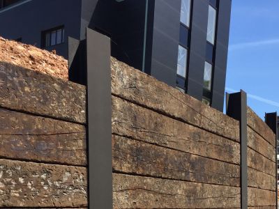 DRAMATIC WALL FROM OLD WEATHERED OAK RAILWAY SLEEPERS SLOTTED INTO STEEL RSJ'S