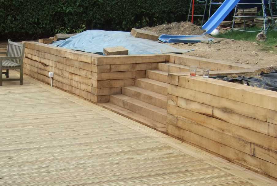Retaining wall and steps built from vertical new oak hardwood railway sleepers. Railwaysleepers.com 